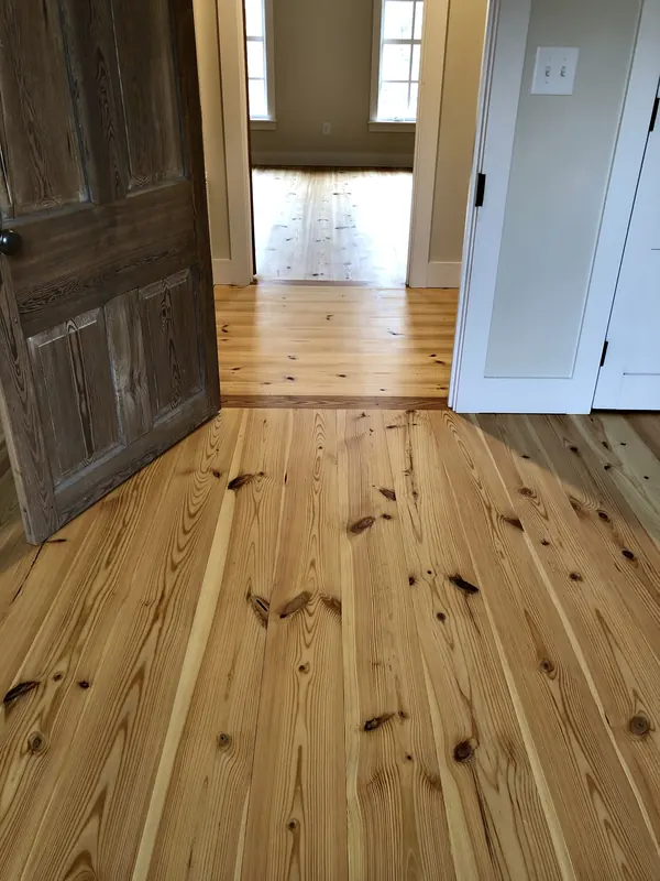 View through a dark door onto a warm pine floor