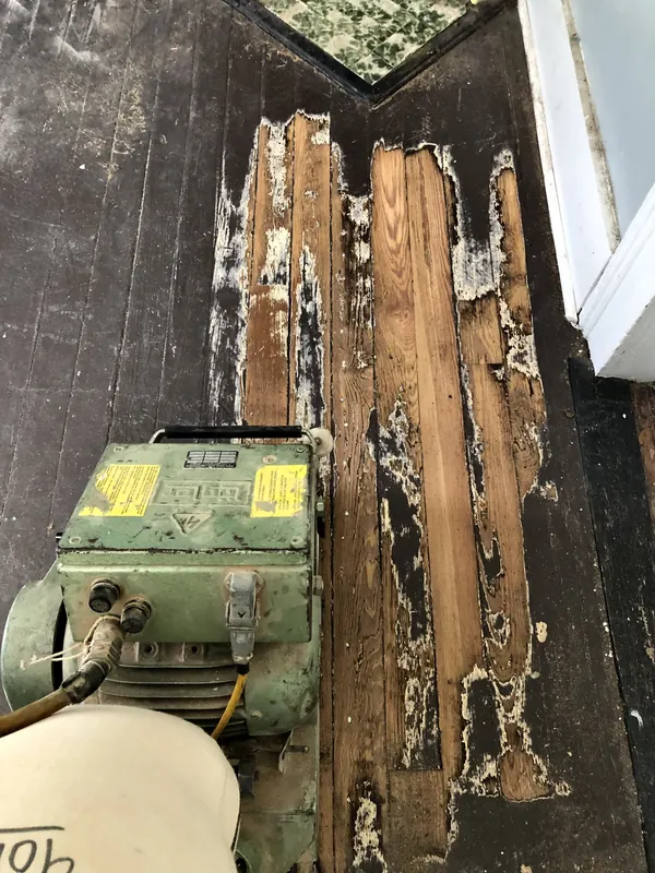 Rotted boards lifted beside a sander, new stock ready