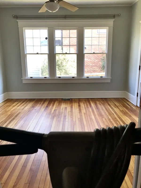 Empty room with pale floor and a bright window